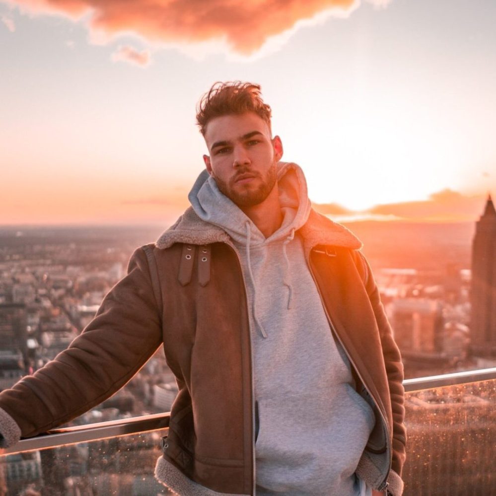 a man standing in front of a sunset