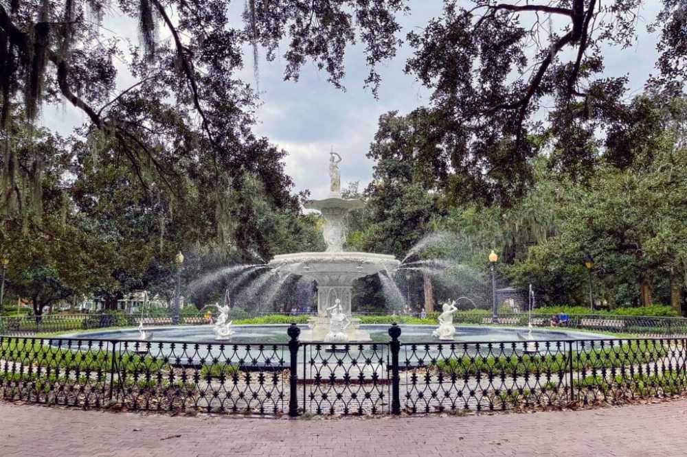 a person sitting on a bench in a park