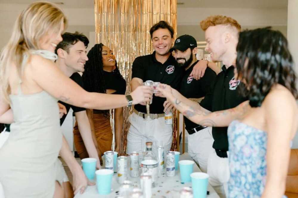 a group of people sitting at a table with a cake