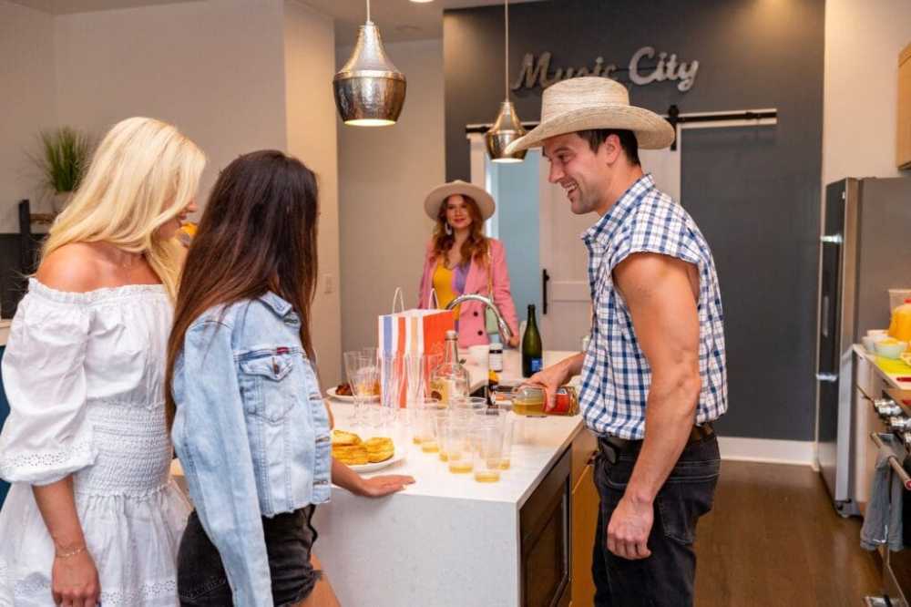 a group of people standing in a kitchen preparing food