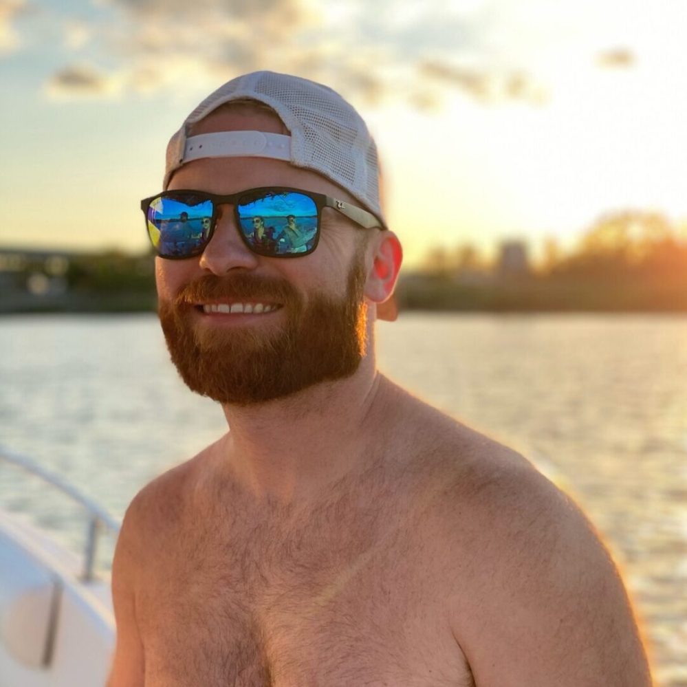 a man standing next to a body of water