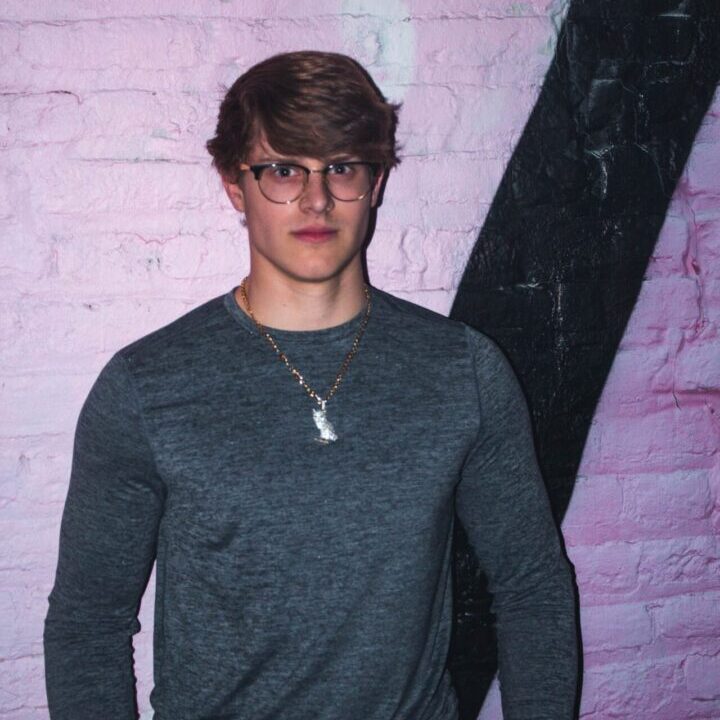 a person standing in front of a brick wall